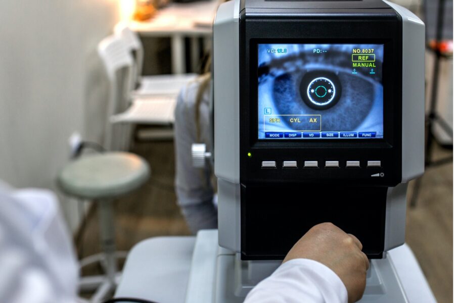 photo of eye exam equipment with doctor's hand working the equipment