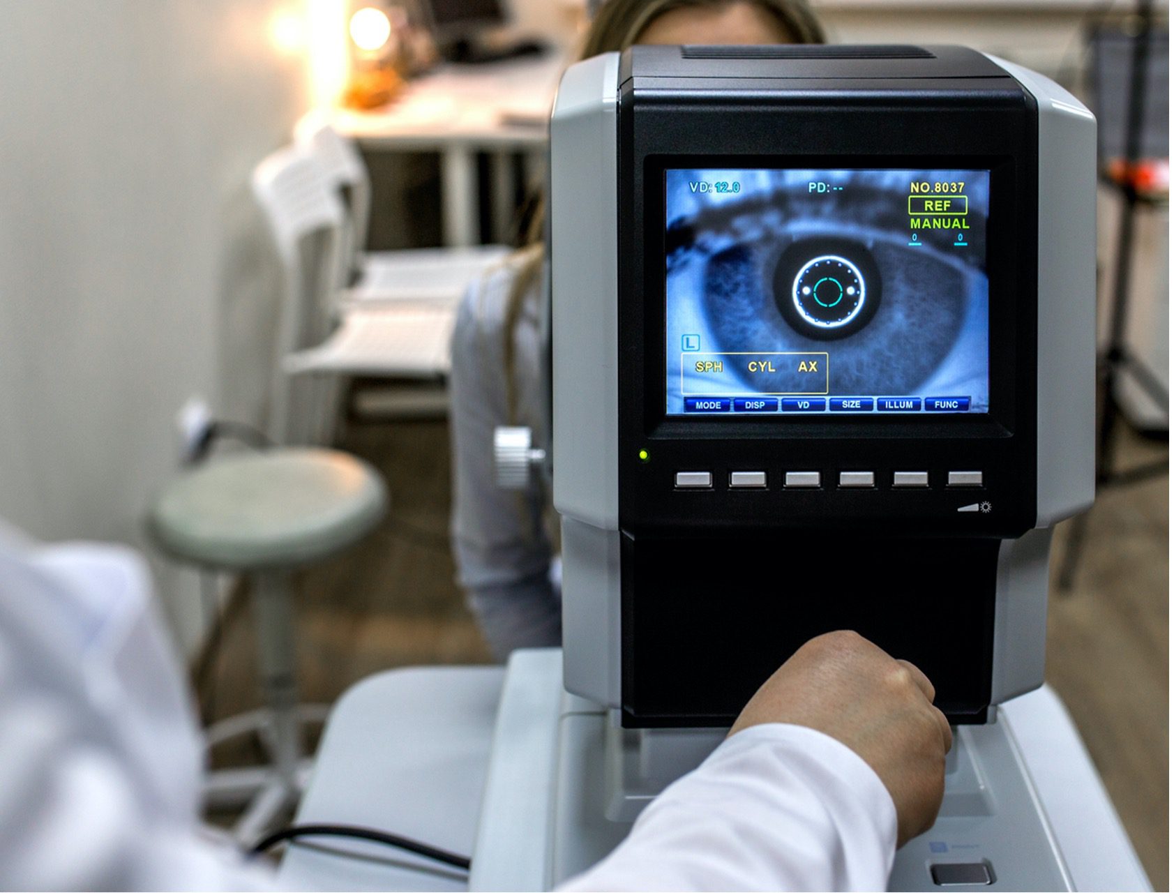 photo of eye exam equipment with doctor's hand working the equipment